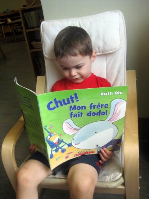 child looking at a book in French