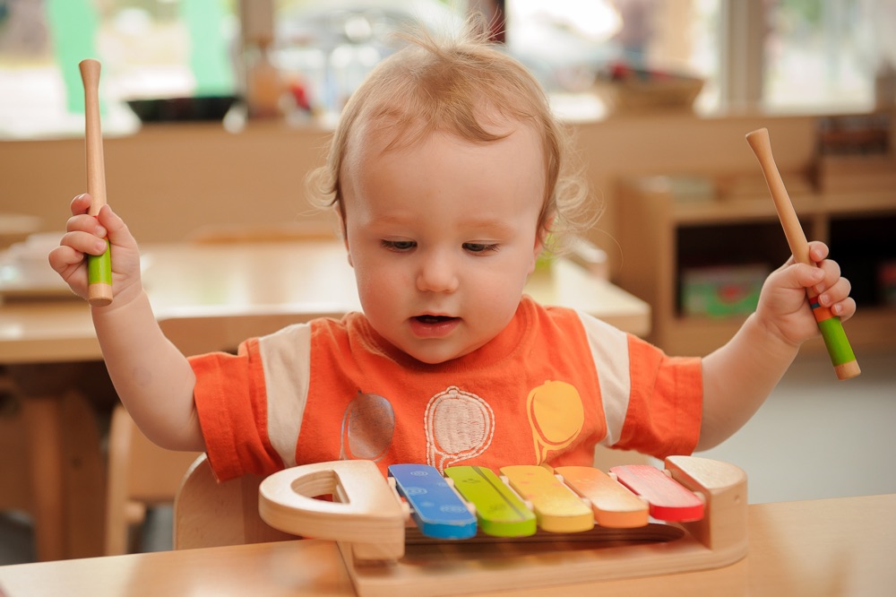 Child under 2 playing a xylophone