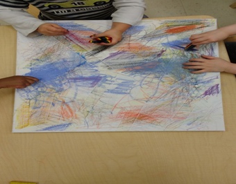 Children under 3 working on oil pastel scribble art 