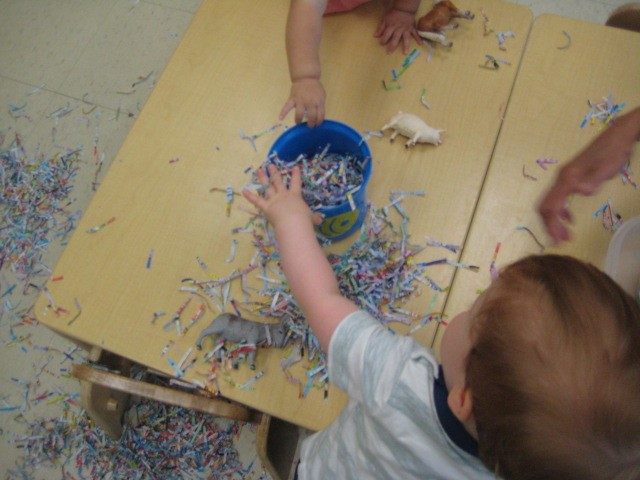 Children under 2 exploring shredded paper 