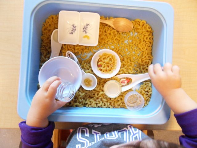 Child scooping pasta 