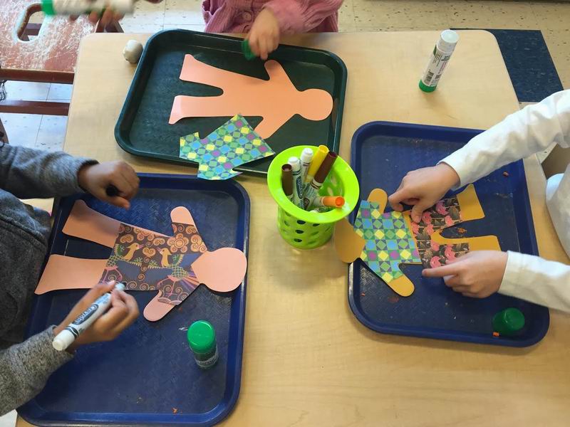 Children colouring on paper dolls