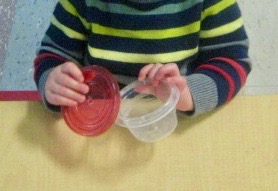child under 2 opening a container