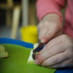 Casa child slicing an apple