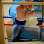 Casa child working on small bead frame