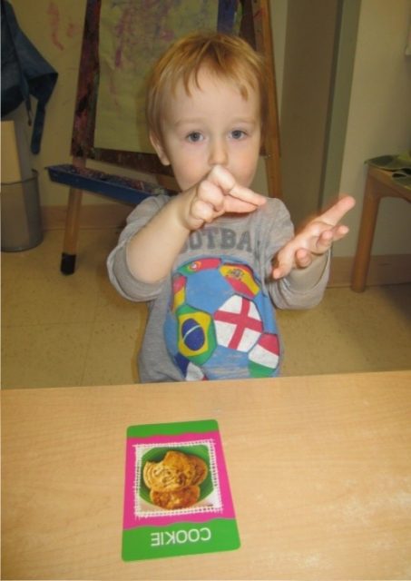 child under 3 making the sign language for cookie