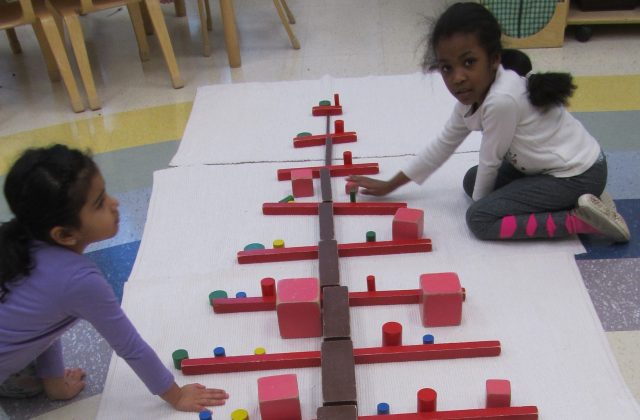 Casa children building a holiday tree using Sensorial materials