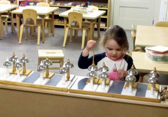 Child playing the Montessori bells