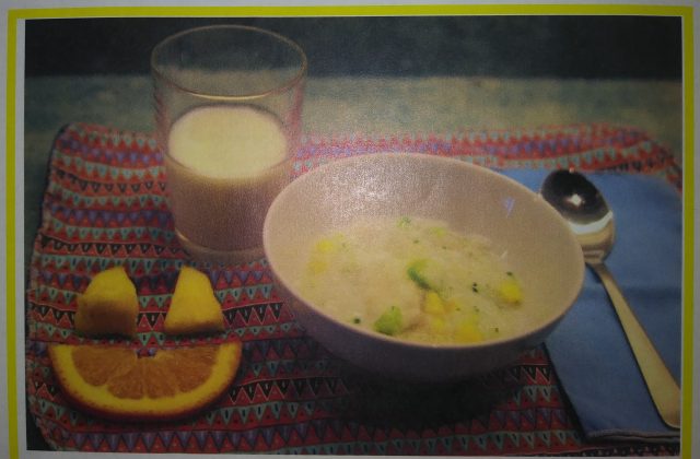 bowl of congee, glass of milk, and fruits on the side