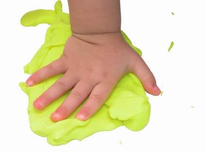 child's hand on playdough
