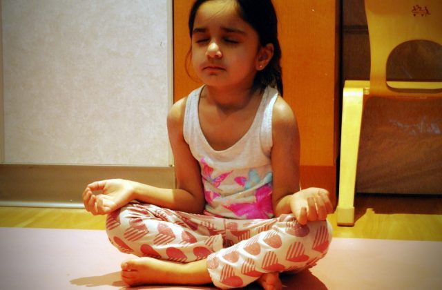 Casa child practicing cupcake breath in yoga class