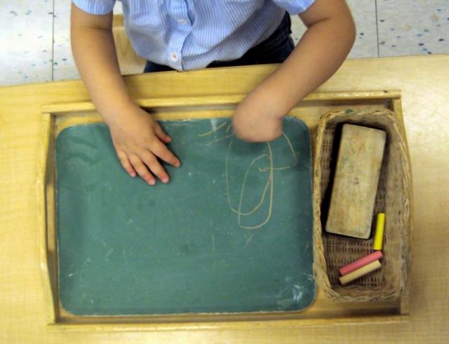 Child colouring with chalk