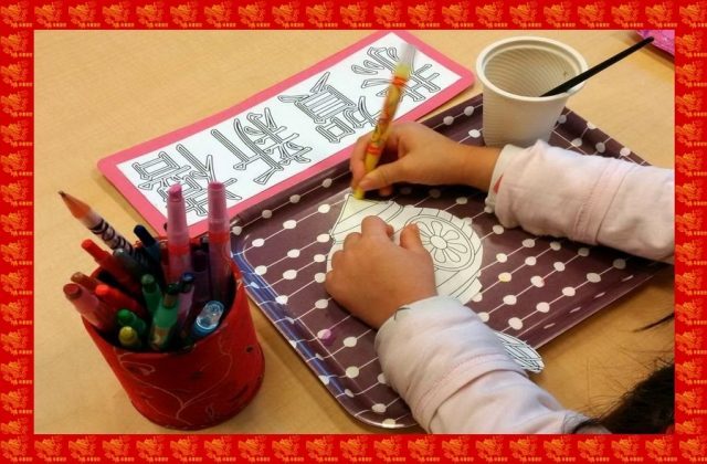 Child colouring on a lantern for Chinese New Year