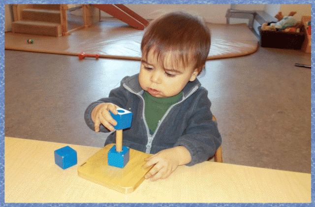 Child working on placing rings on a vertical dowel