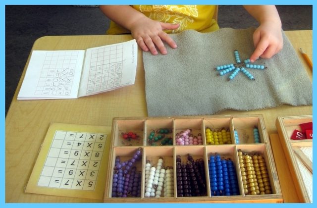 Child working on multiplication with the coloured bead box