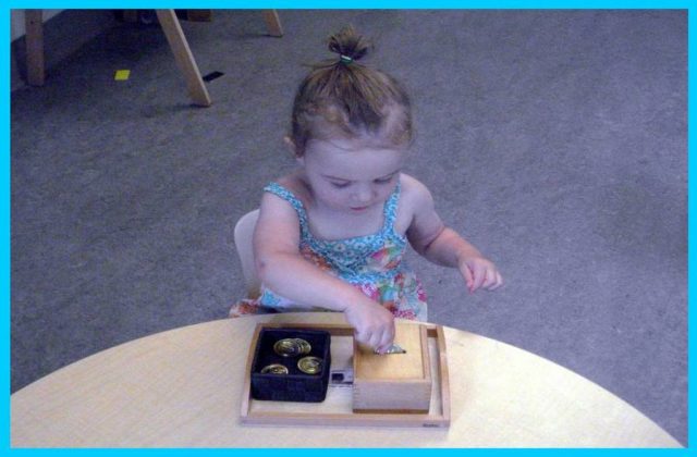 Child inserting discs into a slotted box