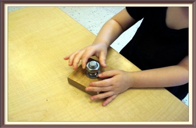 Child practicing with a nut, washer and bolt