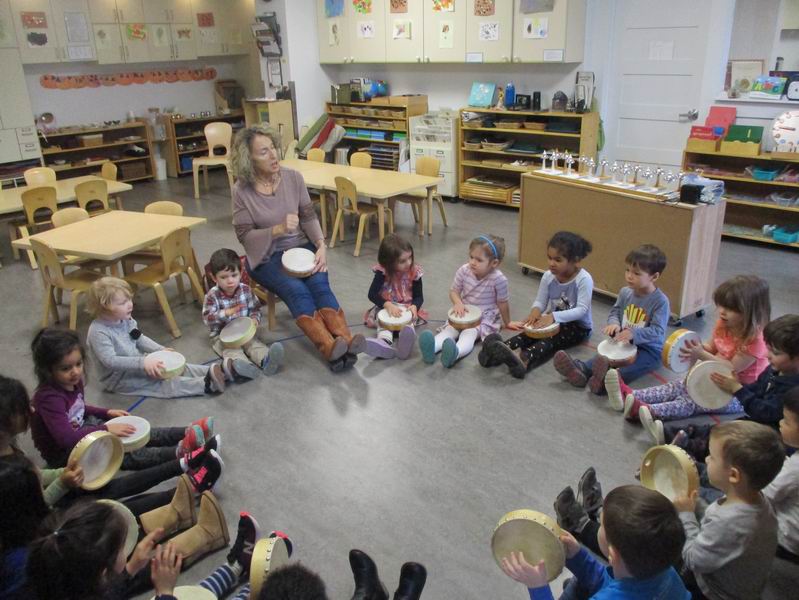 Children playing tambourines with Adriana