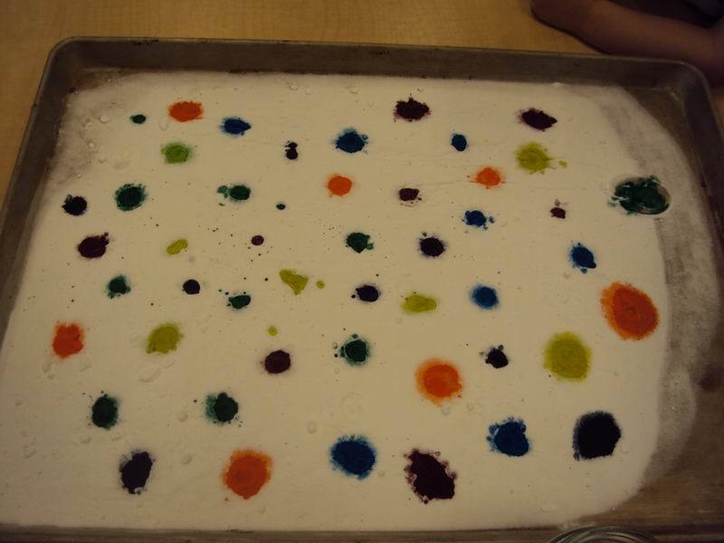 Drops of food colouring in baking soda