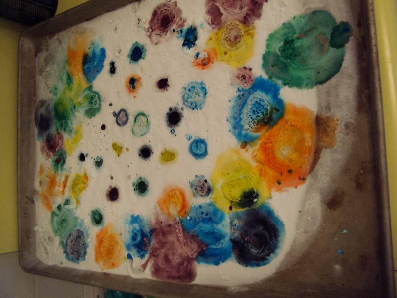 Baking soda, vinegar and food colouring reacting to form bubbles