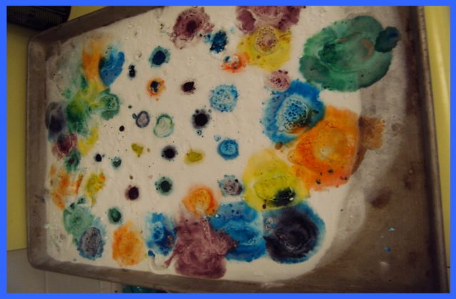 Baking soda, vinegar and food colour reacting to form bubbles