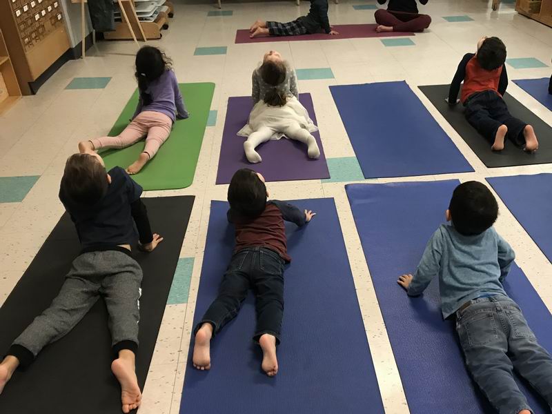 Children doing the "cobra" yoga pose