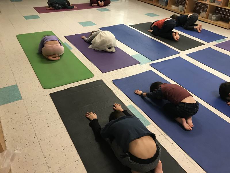 Children doing the "child" yoga pose