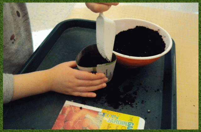 A child filling a biodegradable planter
