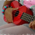 Casa child playing the ukulele