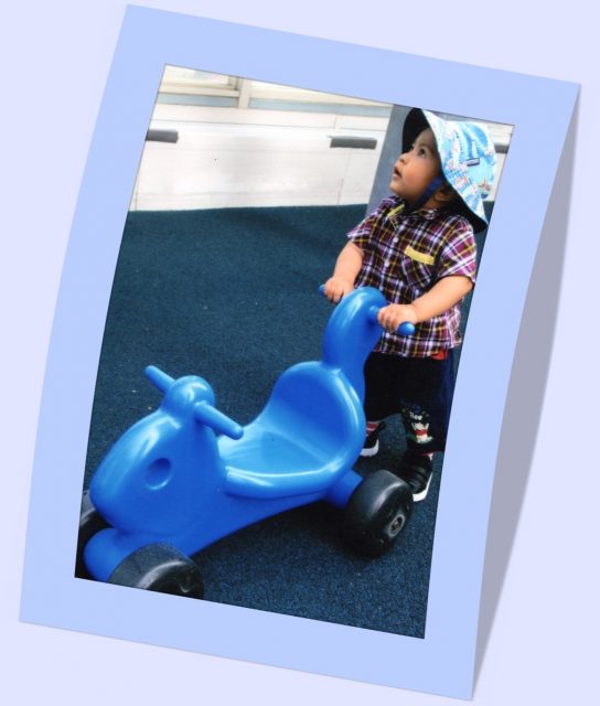 Child under 2 pushing blue scooter