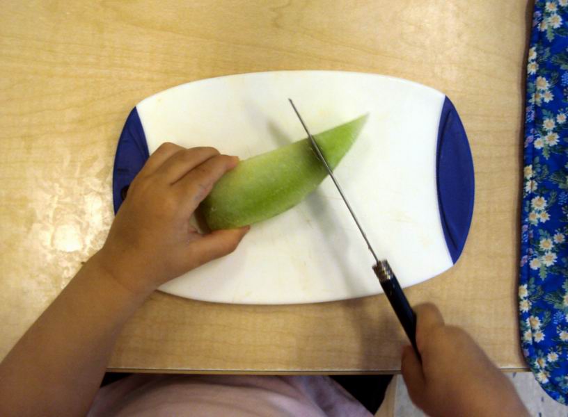 Child cutting a pear