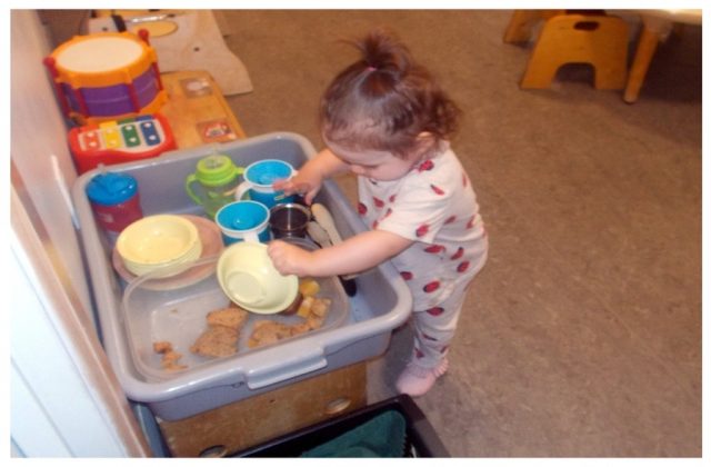 Child under 2 scraping a dish