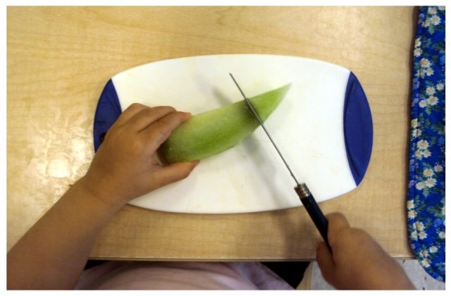 Child cutting a pear