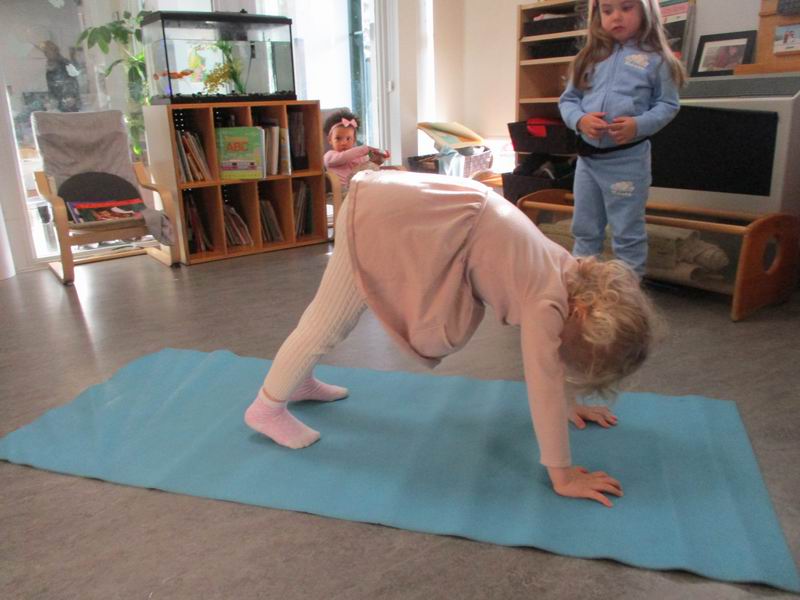 Child practicing the Downward Dog yoga pose