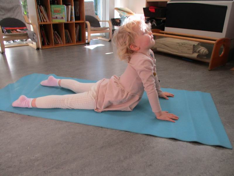 Child practicing the Cobra yoga pose 