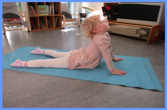 Child practicing the Cobra yoga pose