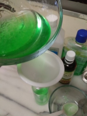 pouring hand sanitizer mixture into bottle