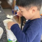 child scooping yogurt