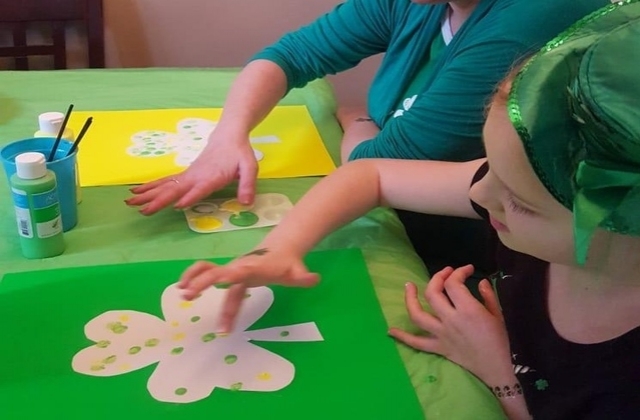 Jen and her daughter fingerpainting on a shamrock