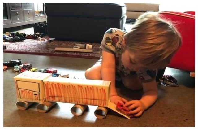 Christina's son using the recycled art truck he made