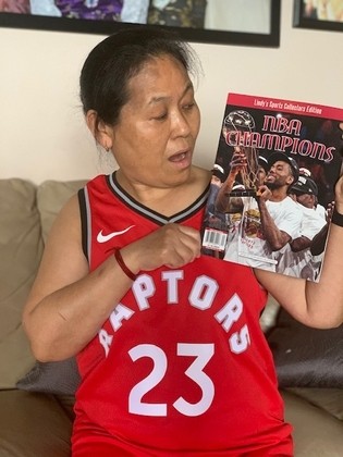 Kalsang looking at the Raptors Championship magazine