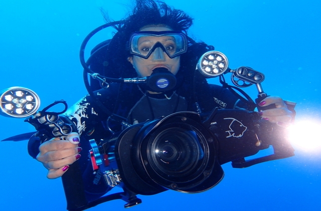 Ayisha scuba diving with a camera