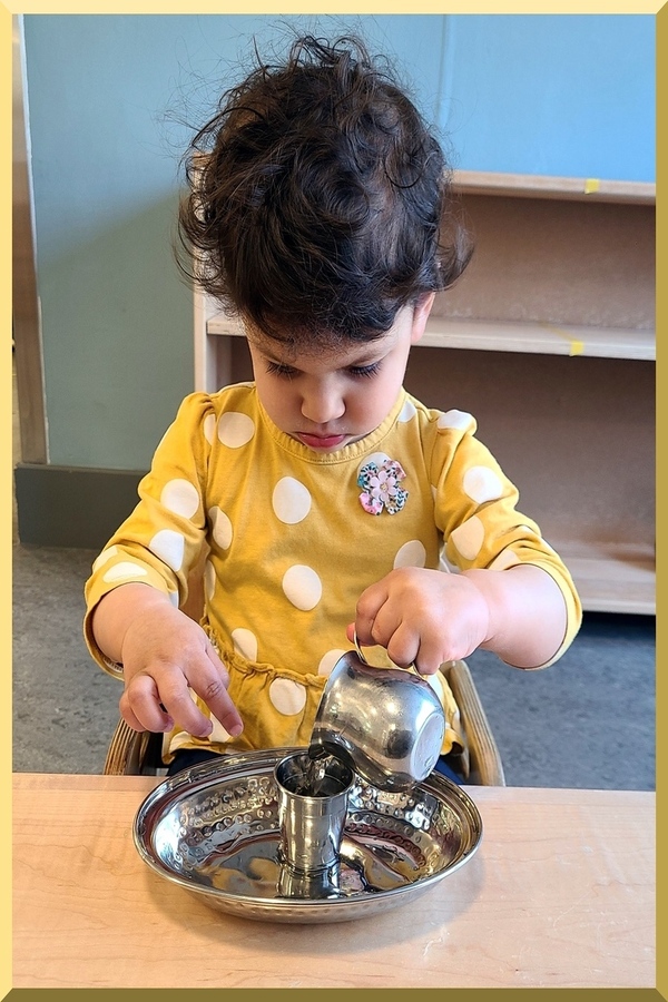 Child pouring water from cup to cup