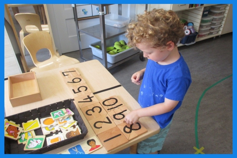 A child working on a wooden number puzzle