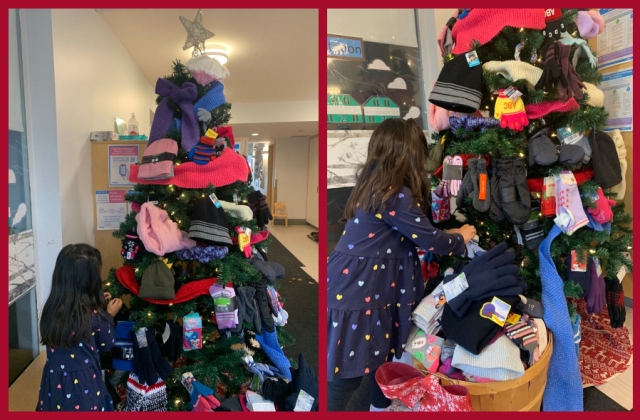 A child placing items on the 'giving tree'