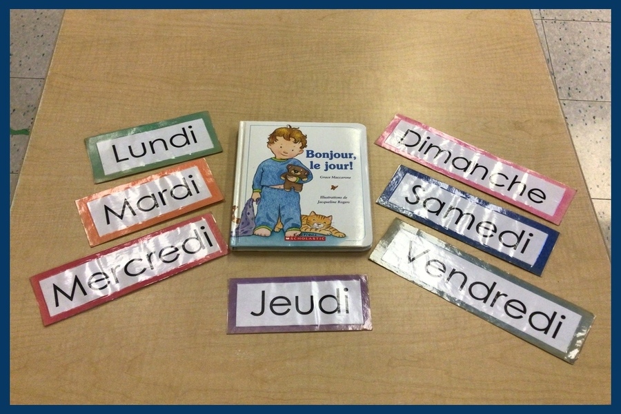 A book 'Bonjour le Jour' with day of the week cards on a table