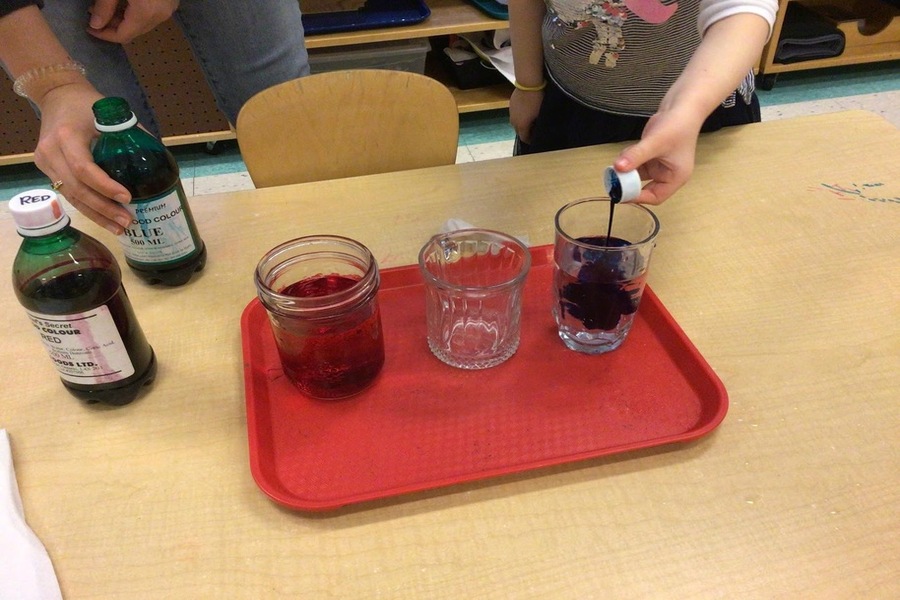Pouring food colouring into water