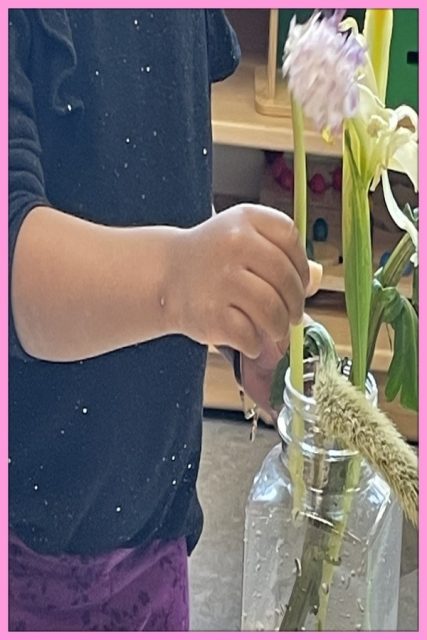 Child under 3 arranging flowers