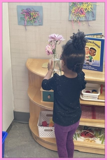 Child under 3 arranging flowers