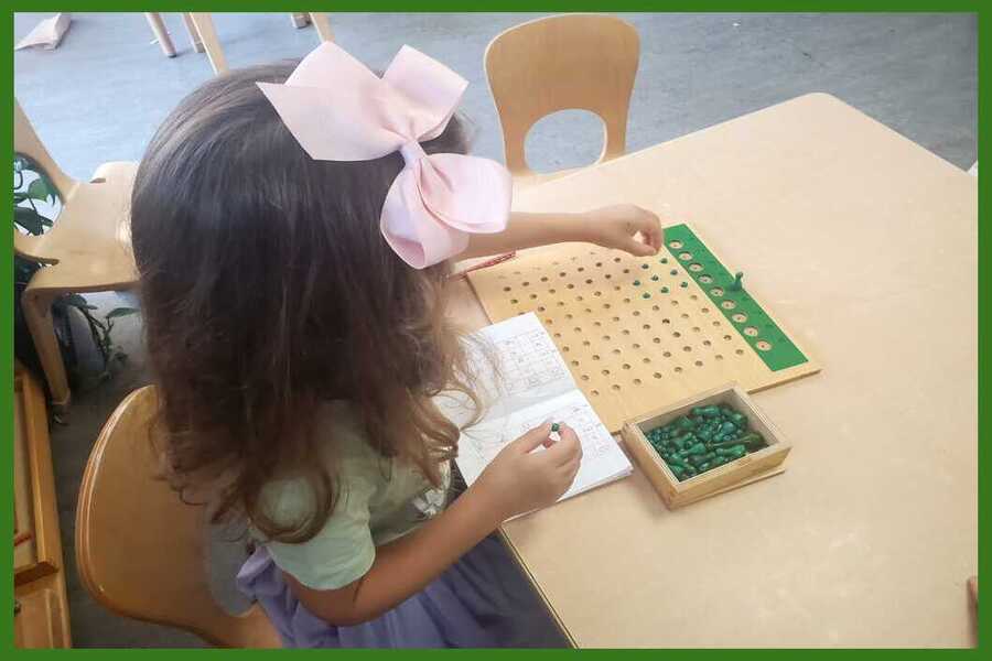 A child working with a Division Board and math notebook